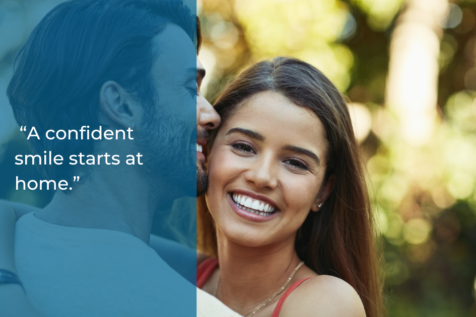 A woman smiling outdoors, with a man next to her and the text "A confident smile starts at home—begin your New Year with oral health" over a blue overlay on the left side of the image.