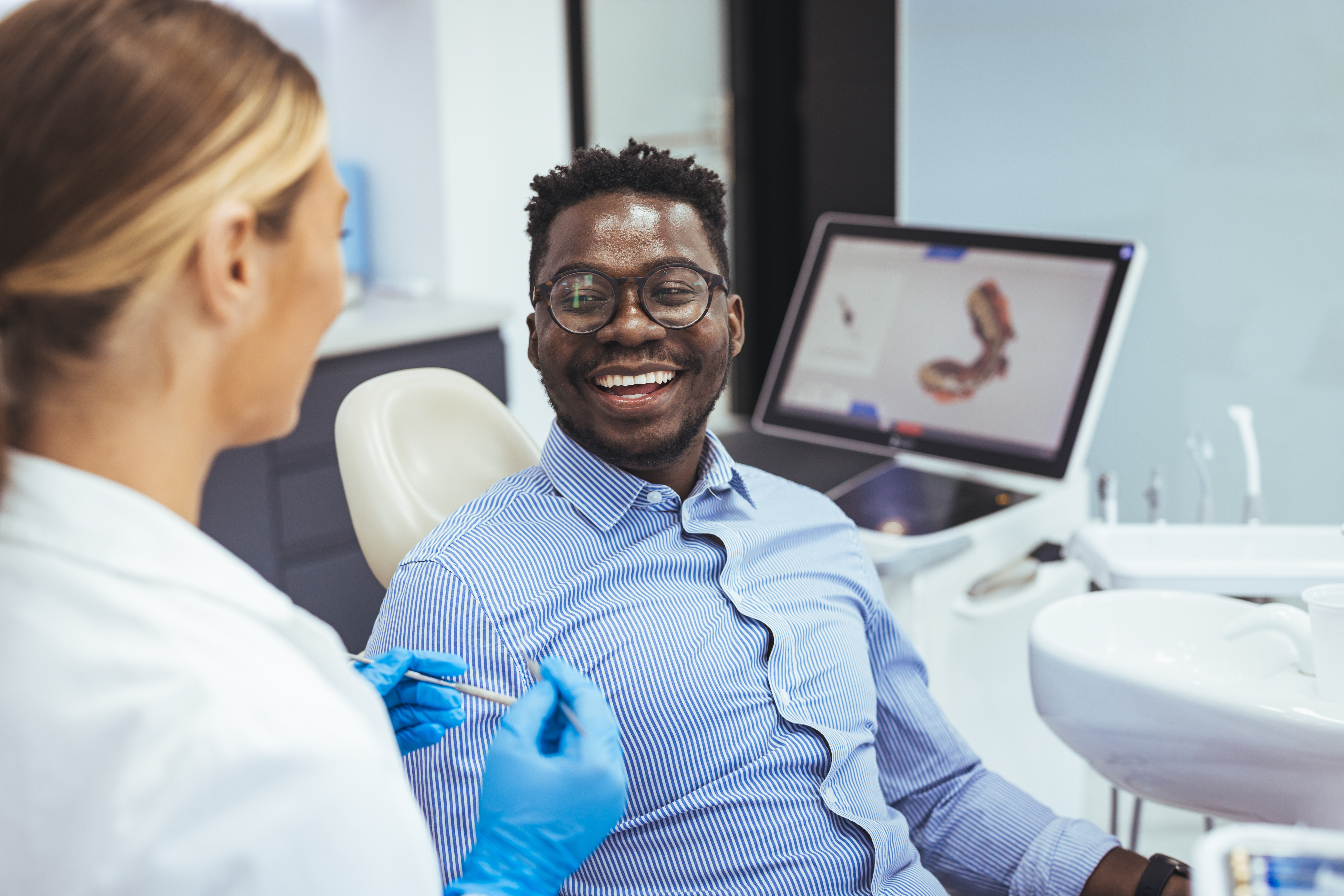 Patient smiling at dentist during a teeth whitening consultation at Montgomery Park Dental
